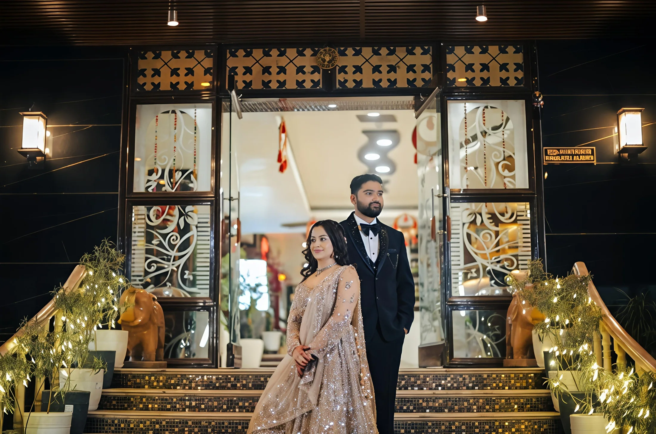 Elegant Indian wedding couple on a grand venue staircase in Mathura